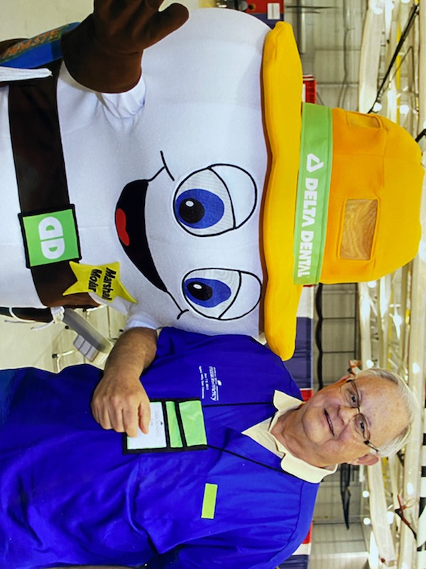 Dr. Lynn Curry smiles and poses for a photo with the Delta Dental Tooth mascot.