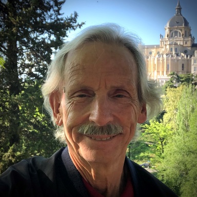 A photo of John Bowers smiling while posing for a photo.