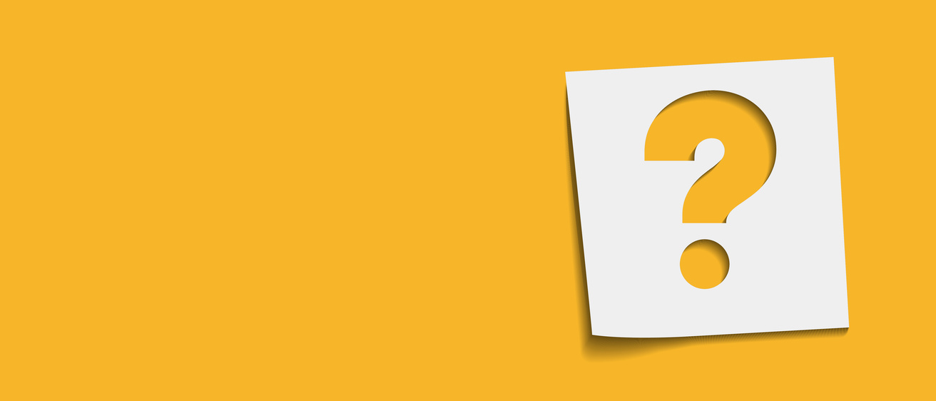 A question mark cut out of a small white piece of paper is displayed against a gold background.
