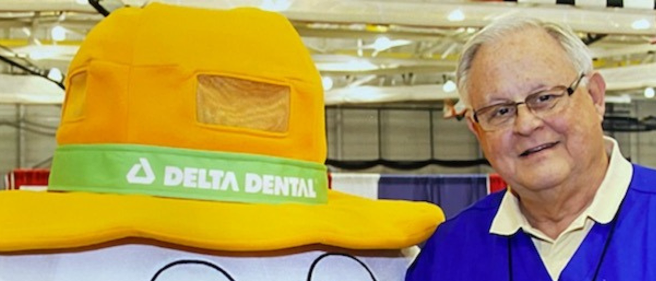 Dr. Lynn Curry smiles and poses for a photo with the Delta Dental Tooth mascot.