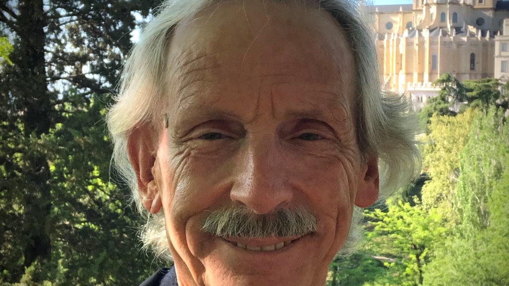 A photo of John Bowers smiling while posing for a photo.